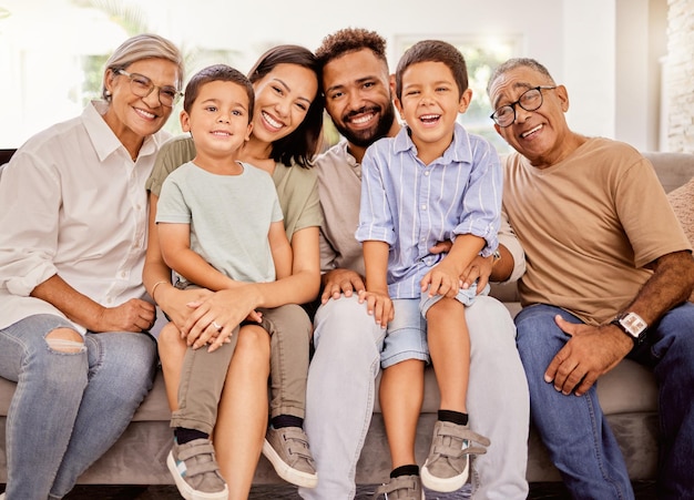 Fröhliche große Familie und Lächeln auf dem heimischen Sofa im Wohnzimmer verbringen wertvolle Zeit, um Liebe zu verbinden und sich gemeinsam zu entspannen Porträt von Eltern, Großeltern und Männern und Frauen mit Kindern, die vor Glück lächeln