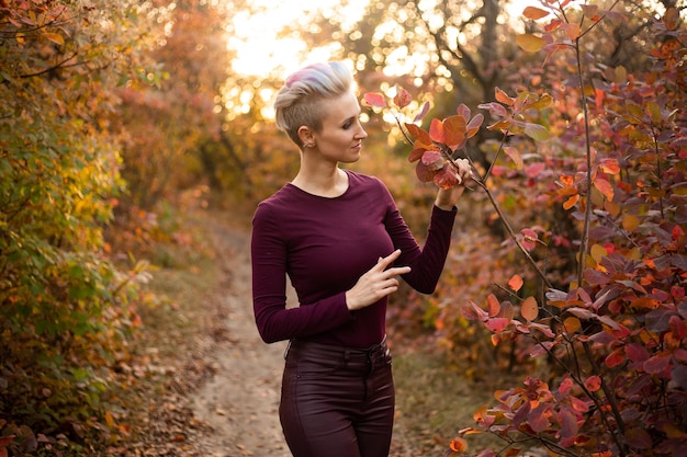 Fröhliche Hipster-Frau, die den Herbst im Park genießt
