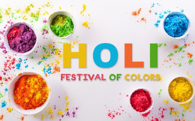 Fröhliche Holi-Dekoration das indische FestivalDraufsicht auf buntes Holi-Pulver mit dem Text auf weißem Hintergrund