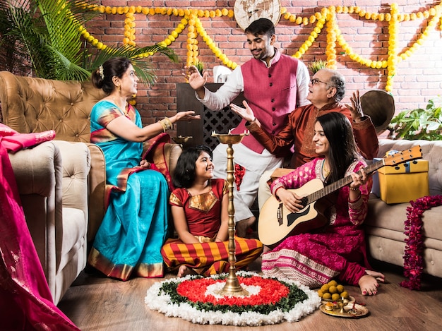 Fröhliche indische Familie singt, spielt Musik, Gitarre, während sie Festivals in traditionellen Kleidern feiert