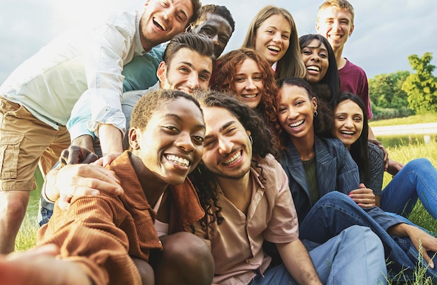 Fröhliche internationale glückliche Freunde, die Spaß daran haben, Selfies beim Picknick auf dem Land zu machen