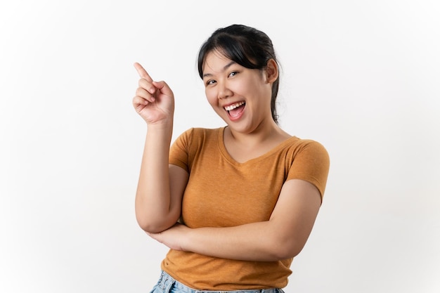 Foto fröhliche junge asiatische frau hat großartige gedanken inspiration finden und mit dem finger nach oben zeigen