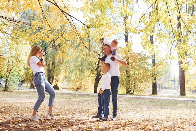 Fröhliche junge Familie macht zusammen einen Spaziergang in einem Herbstpark.