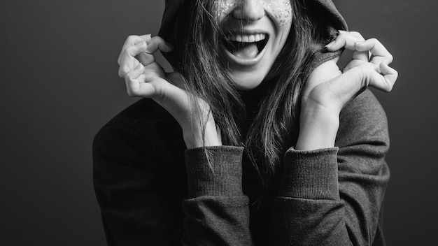 Fröhliche junge Frau, die Gefühle ausdrückt Aufregung Offener Mund Offenes Lächeln Schwarz-Weiß-Porträt