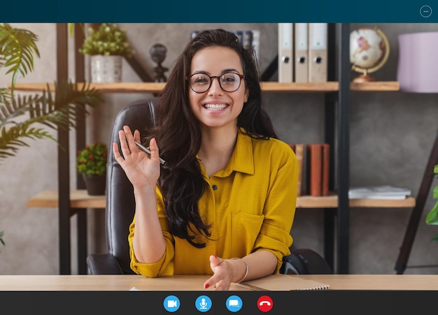 Foto fröhliche junge frau winkt vor der webcam oder führt ein gespräch für einen job-videoanruf