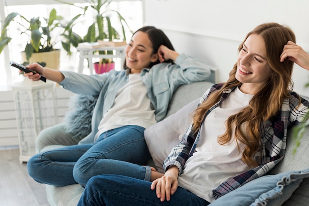 Fröhliche junge Frauen, die fernsehen