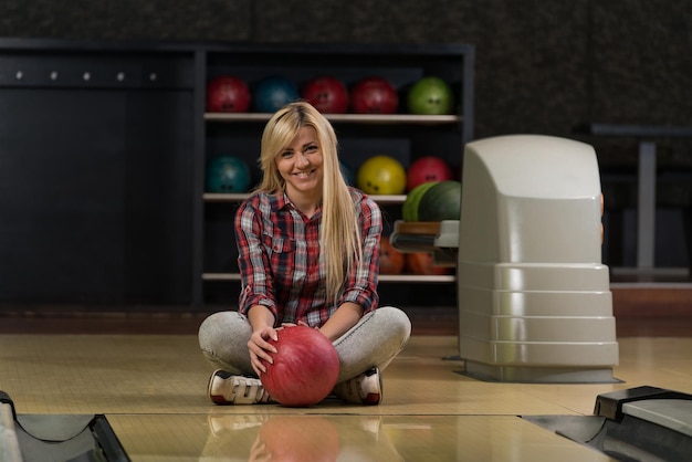 Fröhliche junge Frauen mit Bowlingkugel