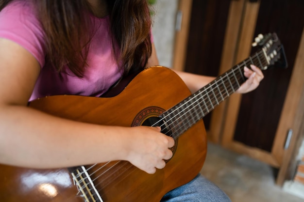 Fröhliche junge Frauenhände, die allein Akustikgitarrenmusiker spielen, komponieren Instrumentalliedunterricht zum Gitarrenspielen