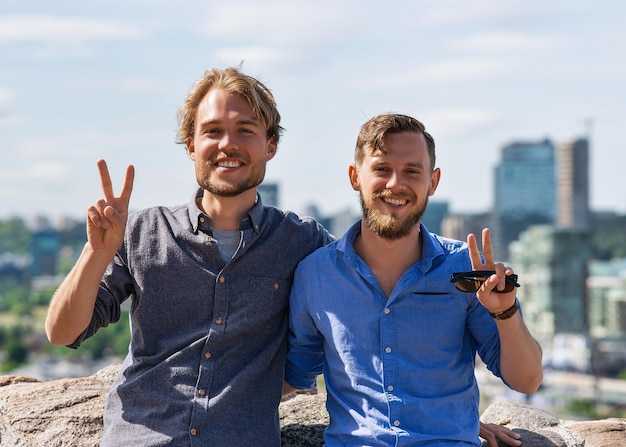 Fröhliche junge kaukasische Freunde im Stadtpanorama als Reise- und Freundschaftskonzept