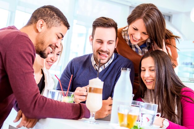 Fröhliche junge Leute, die sich in einem Café amüsieren