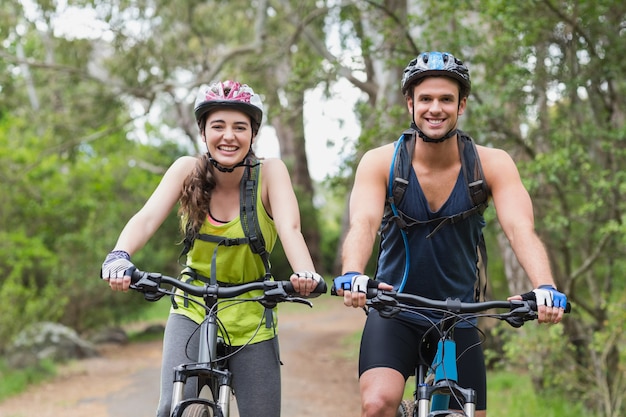 Fröhliche junge Paar mit Mountainbikes auf Fußweg
