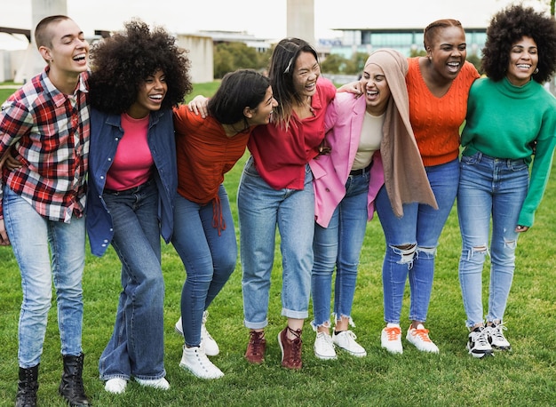 Fröhliche junge, vielfältige Frauen, die sich im Freien amüsieren Multirassische Freundinnen genießen den Tag im Stadtpark
