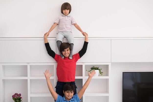 Fröhliche Jungs, die Spaß haben und posieren, huckepack in einem neuen modernen Zuhause