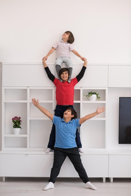 Fröhliche Jungs, die Spaß haben und posieren, huckepack in einem neuen modernen Zuhause