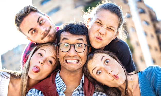 Fröhliche Jungs und Mädchen, die lustige Selfies in der Stadt machen