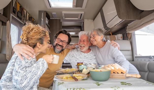 Fröhliche kaukasische Familie, die in einem Wohnmobil sitzt und sich umarmt und eine gute Zeit genießt