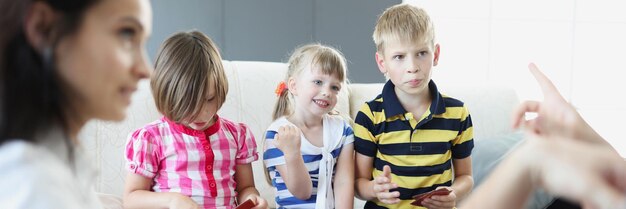 Fröhliche Kinder beim Kartenspiel mit den Eltern zu Hause