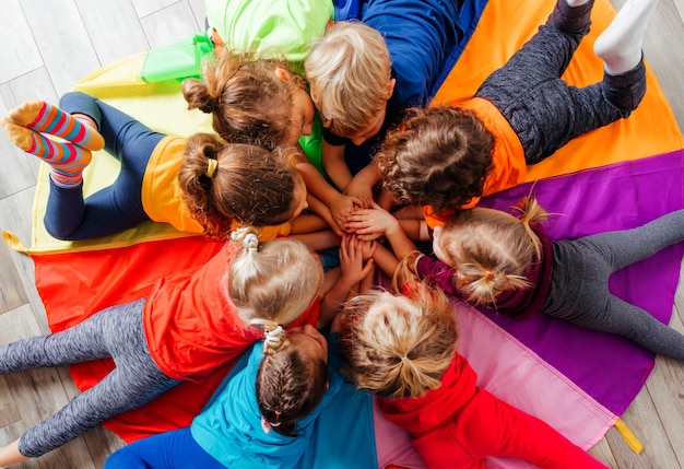 Foto fröhliche kinder, die teambuilding-spiele auf einer etage spielen