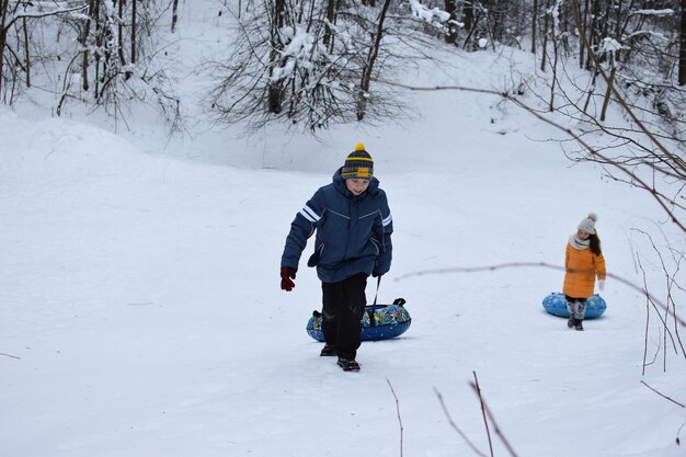 Fröhliche Kinder in den Winterferien. Kinder auf den Schneerutschen