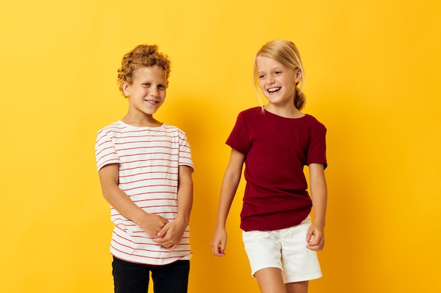 Fröhliche Kinder kuscheln Mode Kindheit Unterhaltung gelben Hintergrund