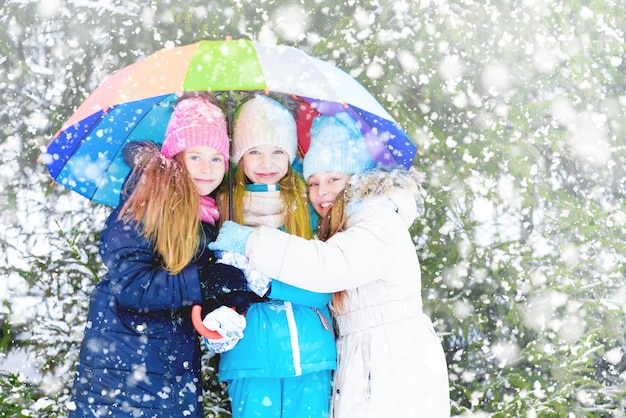 Fröhliche Kindermädchen, die in starkem Schneefall spazieren gehen