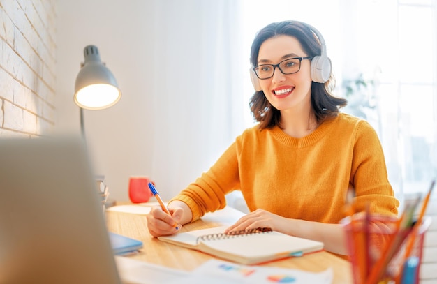 Fröhliche, lässige, schöne Frau, die im Home Office arbeitet.