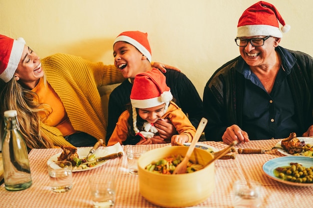 Fröhliche lateinamerikanische Familie, die gemeinsam beim Weihnachtsessen feiert. Konzentrieren Sie sich auf das Gesicht des Großvaters