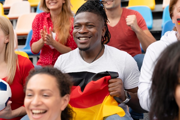 Foto fröhliche leute schauen sich ein fußballspiel an