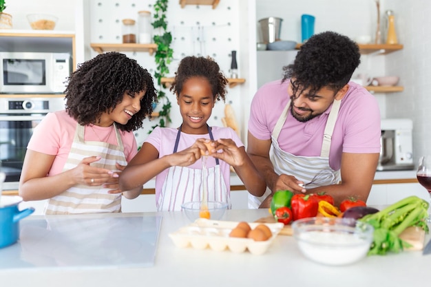 Fröhliche liebevolle Familie bereitet gemeinsam Bäckerei zu Mutter Vater und Kind Tochter Mädchen kochen Kekse und haben Spaß in der Küche Hausgemachtes Essen und kleiner Helfer