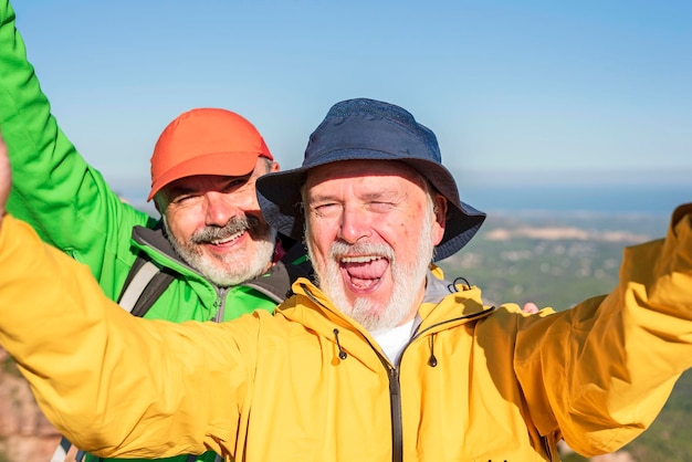 Fröhliche, lustige ältere Freunde, die sich beim gemeinsamen Wandern selbst machen