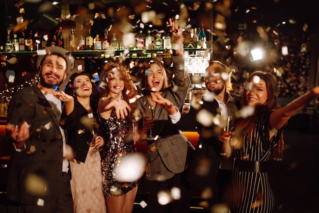 Fröhliche Menschen, die zusammen mit Champagner-Party-Feierkonzept Winterferien feiern