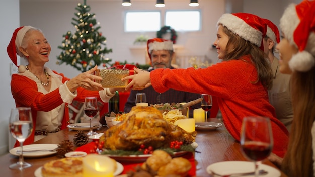 Fröhliche Menschen mit Weihnachtsmütze feiern gemeinsam den Weihnachtstag