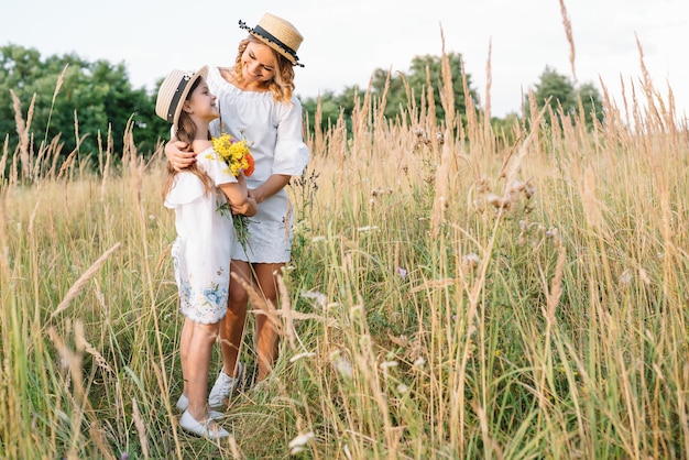 Foto fröhliche mutter und ihre kleine tochter haben gemeinsam spaß auf der sommeroberfläche