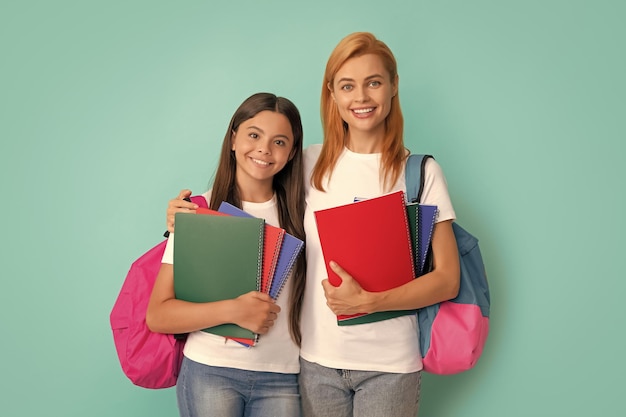 Fröhliche Mutter und Tochter halten Notizbuch und Rucksack bereit, um das Lernen zu lernen