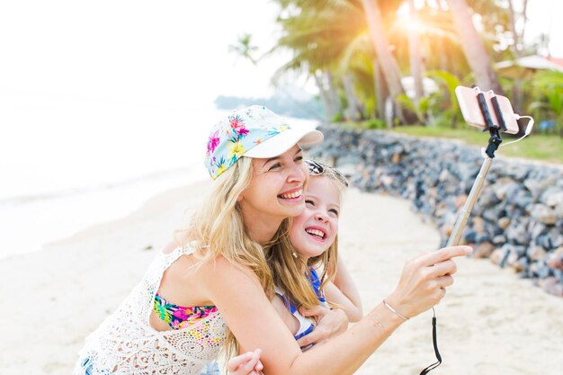 Foto fröhliche mutter und tochter machen ein selfie am strand