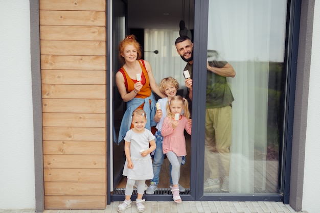 Fröhliche nette Familie, die Eis in ihren Händen hält