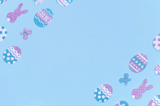 Fröhliche Osterecke mit Kopierbereich Hasen und Eier aus dekorativem Glitzerpapier auf blauem Hintergrund Kann als Postkartenbanner oder Hintergrund verwendet werden