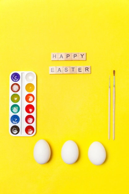 Fröhliche ostern-konzeptvorbereitung für die feiertagsaufschrift frohe ostern beschriftet eier bunte farben i