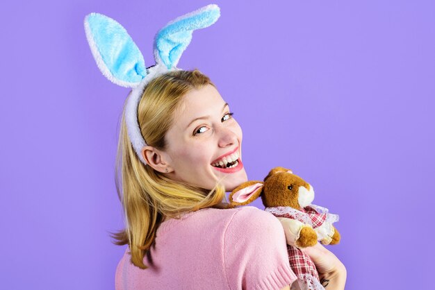 Fröhliche Ostern. Lächelndes Mädchen mit Plüschhasen-Spielzeug.