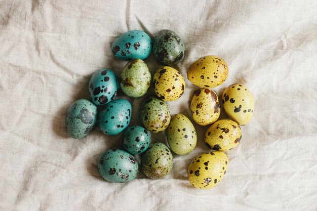 Fröhliche Ostern Stilvolle Ostereier auf rustikalem Tisch Rustikale Osterwohnung lag Natürlich bunt bemalte Wachteleier auf Leinenstoff Stillleben