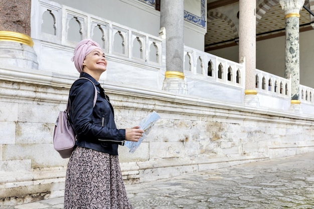 Fröhliche Reisende, die in ihren Händen eine Karte halten und einen schönen Blick auf den Topkapi-Palast Istanbul Türkei sehen Historischer Reiseurlaub