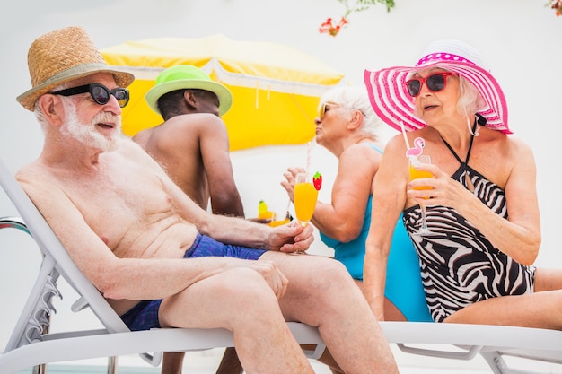 Fröhliche Senioren feiern im Schwimmbad Ältere Freunde bei einer Poolparty im Sommer