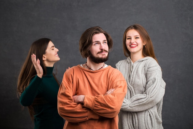 Fröhliche Teenager, die Spaß am Glückskonzept haben, Innenaufnahme im grauen Hintergrund