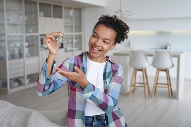 Fröhliche Teenie-Mädchen Hausbesitzerin hält Schlüssel zu neuem Haus Immobilienmiete erste eigene Wohnung