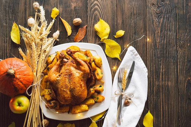 Fröhliche Thanksgiving-Herbstkomposition mit Blättern, reifem Kürbis und Thanksgiving-Truthahn auf einem dunklen Holztisch Draufsicht