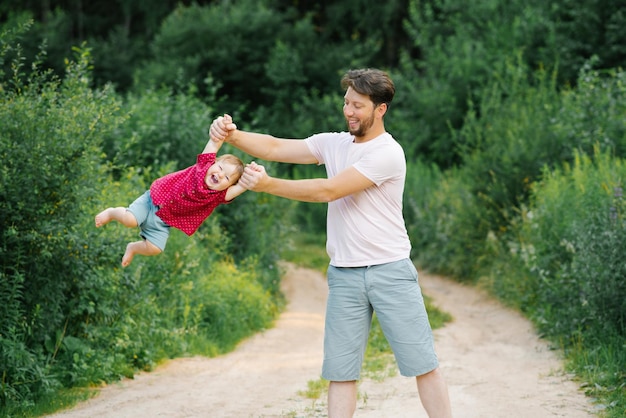 Fröhliche und süße Momente eines Sommerspaziergangs im Park eines Vaters und eines kleinen Sohnes