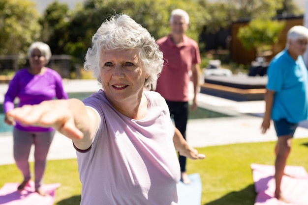Foto fröhliche, vielfältige ältere freunde, die im sonnigen garten yoga praktizieren. seniorenlebensstil, aktiver ruhestand, freundschaft, gesundheit und wohlbefinden, unverändert.