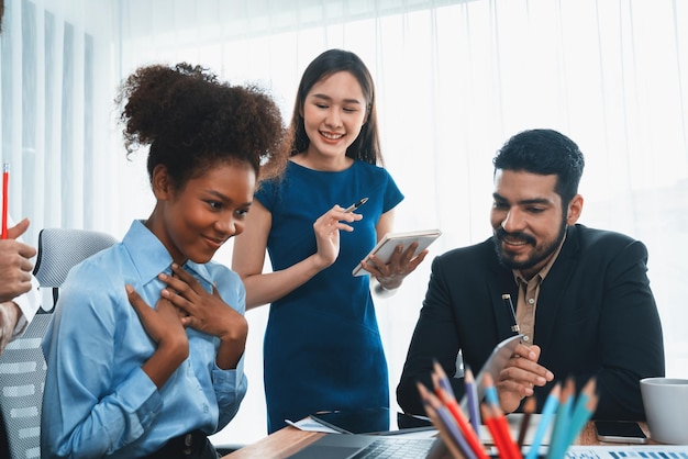 Fröhliche, vielfältige Geschäftsleute arbeiten zusammen und diskutieren im Firmenbüro. Professionelle und vielfältige Teamarbeit besprechen den Geschäftsplan auf dem Schreibtisch mit dem Laptop. Moderner multikultureller Büroangestellter Concord