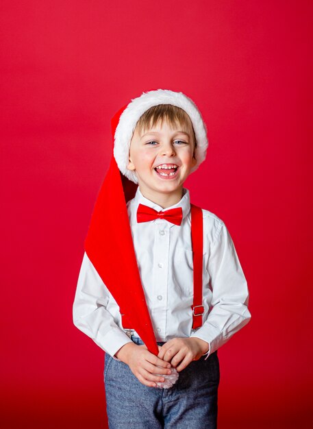 Fröhliche Weihnachten. Netter netter kleiner Junge in Santa Claus-Hut