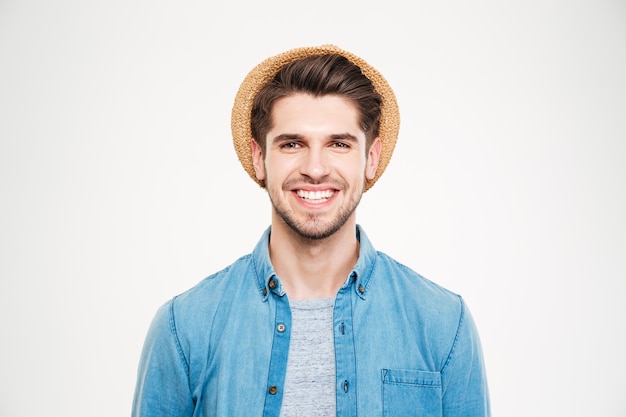 Fröhlicher attraktiver junger Mann mit Hut und blauem Hemd auf weißem Hintergrund